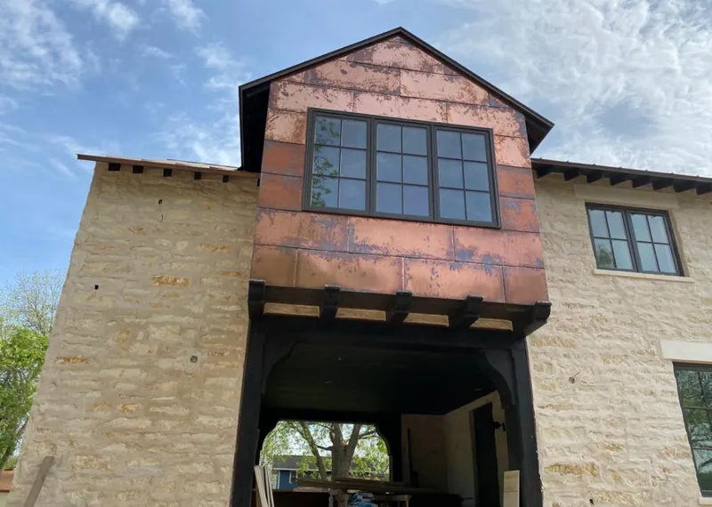 Copper metal panel facade on a stone building for Skylight Installation in Addison