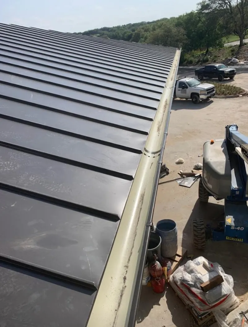 Standing seam panel and gutter detail on a metal roofing jobsite in Addison